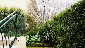 A staircase with a green railing leading up to a white wall.