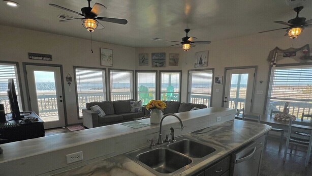 A kitchen with a large island, two sinks, and ceiling fans. - Pompano - Beachfront - Island Realty (Grand Isle)