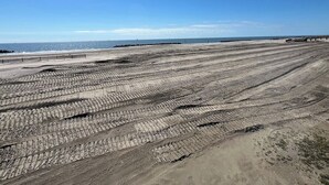 A large, open area with a patterned ground surface, possibly a parking lot or construction site, with a clear sky and distant horizon. - Pompano - Beachfront - Island Realty (Grand Isle)