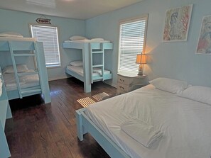 A bunk bed room with a single bed, a nightstand, and a wall sign. - Pompano - Beachfront - Island Realty (Grand Isle)