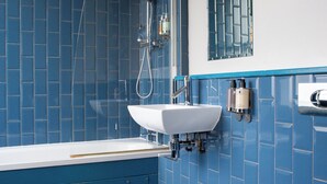 A bathroom with a bathtub, a sink, and a toilet. - The Ship Rooms (London)