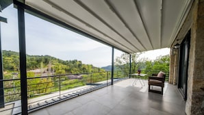 A spacious balcony with a view of a lush green landscape and distant hills. - Assosa Country House (Ayvacik)