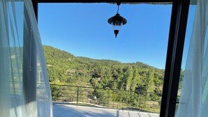 A room with a large sliding glass door leading to an outdoor terrace. - Assosa Country House (Ayvacik)