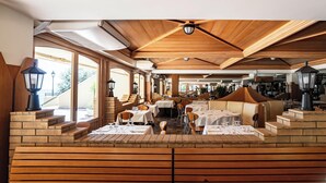 A restaurant with wooden ceiling beams, brick walls, and tables set for dining. - Hotiday Apartment Collection-Pugnochiuso (Vieste)