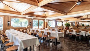 A spacious dining area with multiple tables and chairs, large windows, and a wooden ceiling. - Hotiday Apartment Collection-Pugnochiuso (Vieste)