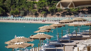 A beach with rows of sun umbrellas and lounge chairs. - Hotiday Apartment Collection-Pugnochiuso (Vieste)