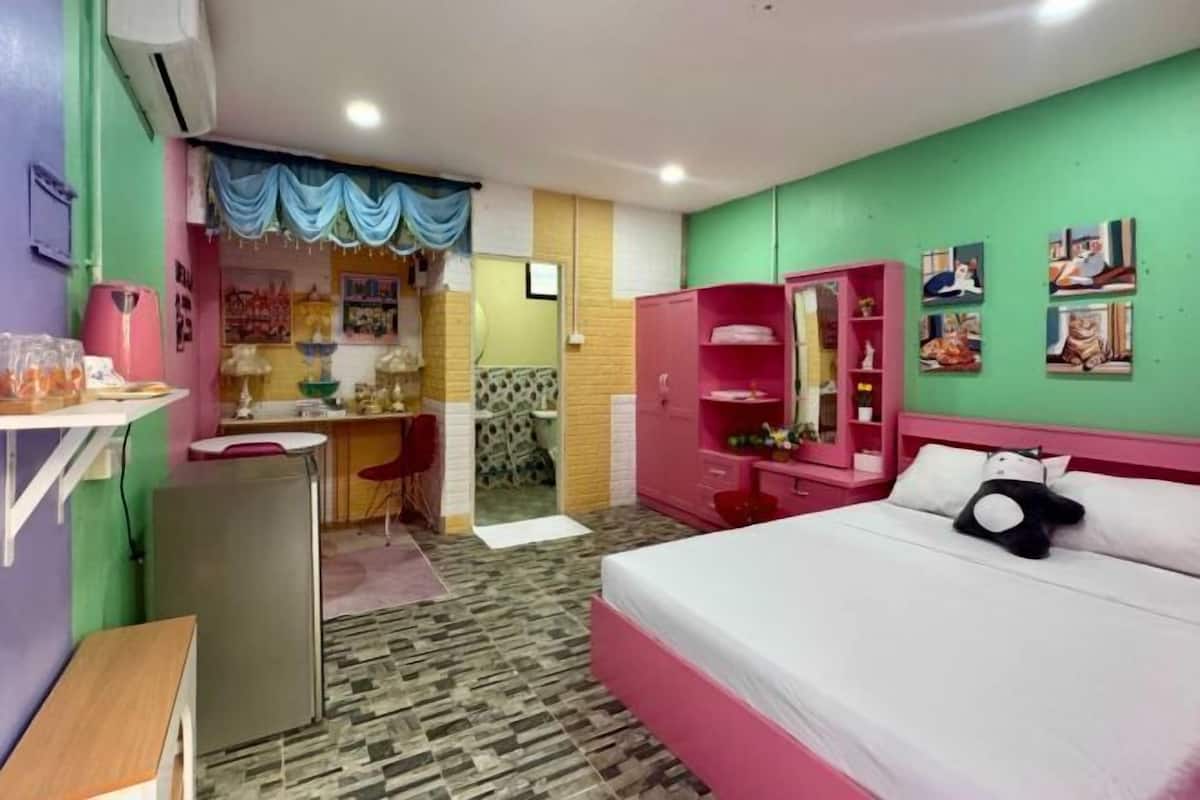 A room with a bed, desk, chair, and wardrobe.
