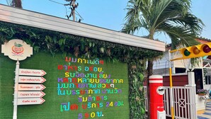 A wall with directional signs and a cafe sign. - OYO 75539 Phanthida Resort and Cafe (Pranburi)