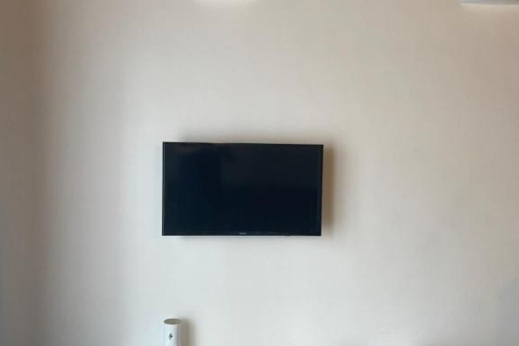 A flat-screen TV mounted on a plain white wall.