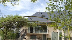 A two-story house with a balcony, a staircase, and potted plants. - Merry Méry (Mery)