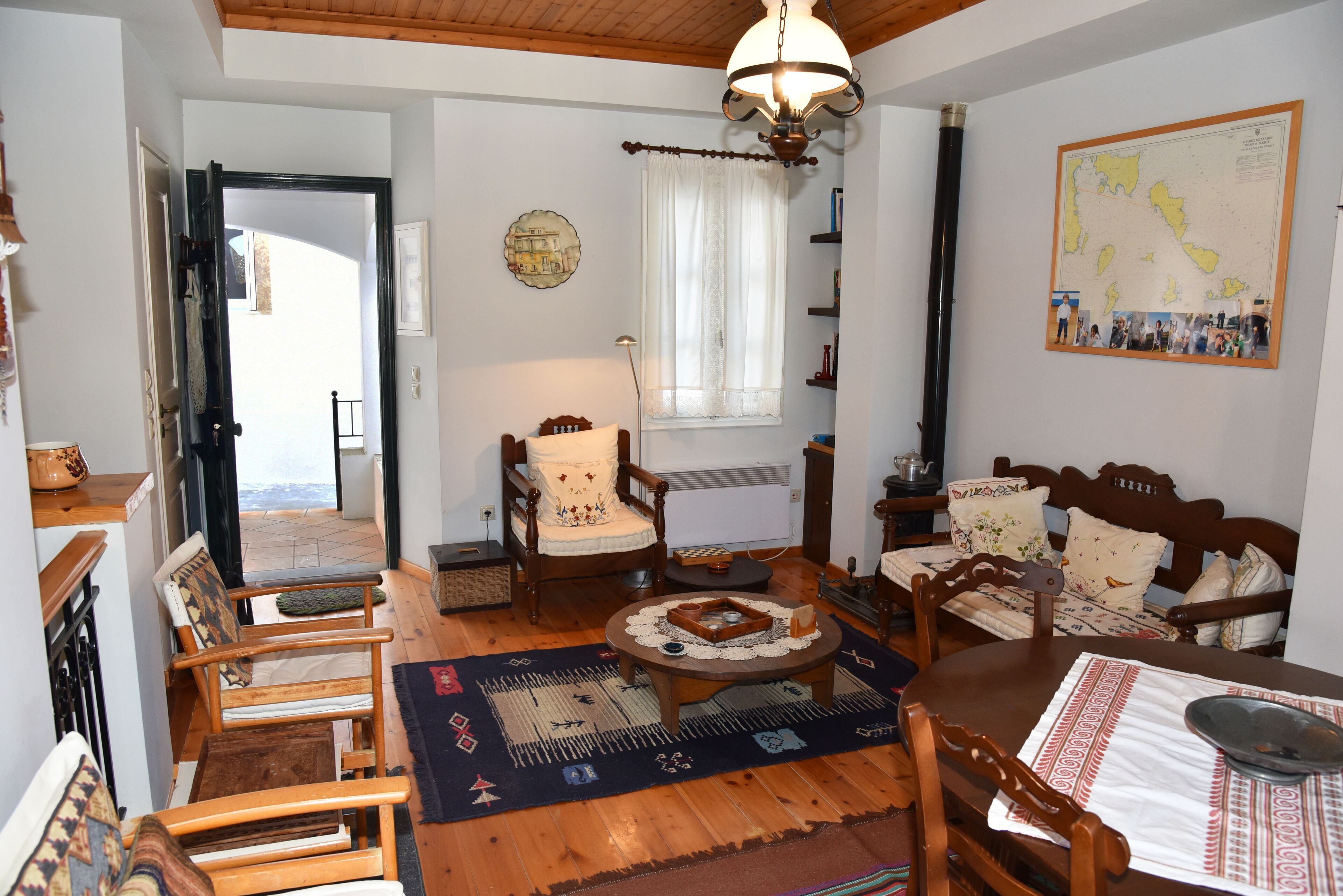Un salón acogedor con muebles de madera, una mesa redonda y un mapa en la pared.