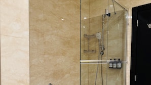 A modern bathroom with a glass-enclosed shower, a white bathtub, and a black door. - Hotel Rivo Timisoara (Timisoara)