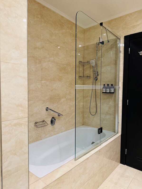 A modern bathroom with a glass-enclosed shower, a white bathtub, and a black door. - Hotel Rivo Timisoara (Timisoara)