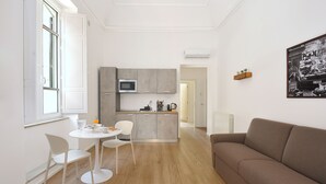 A modern apartment with a kitchen, dining area, and living room. - Palazzo Gregorietti Boutique Apartments (Palermo)
