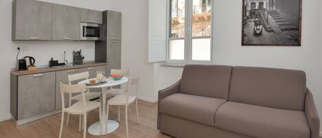 A modern apartment with a kitchen, dining area, and a living room.