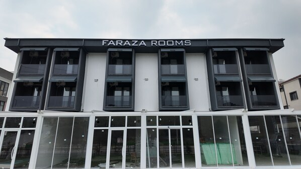 Un edificio con el letrero "FARAZA ROOMS", que indica un hotel o alojamiento.
