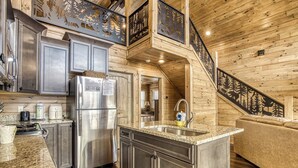 A modern kitchen with granite countertops, stainless steel appliances, and a wooden interior. - Smoky Mountain Dreamin'-Mountain Views, Hot Tub, $560 tickets each paid day! (Sevierville)