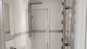 Une salle de bain moderne équipée d’une douche, de toilettes et d’un lavabo.