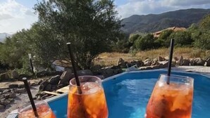 A poolside view with three people holding glasses. - Pasare Glamping (Perfugas)