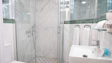 Habitación doble Confort, 1 cama Queen size, para no fumadores | Baño | Regadera, amenidades de baño gratuitas, secadora de cabello, toallas