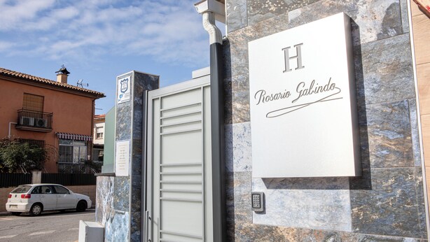 L’entrée d’un hôtel, avec une façade en marbre, une plaque portant le nom « Rosario Salindo » et un clavier permettant d’accéder aux chambres.
