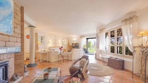 A spacious living room with a fireplace, a dining area, and a view of the outdoors. - House for 10 people with private pool in Sainte-Maxime. (Sainte-Maxime)