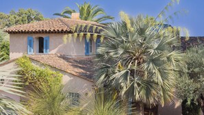 A rustic house with a tiled roof, blue shutters, and lush greenery including palm trees. - House for 10 people with private pool in Sainte-Maxime. (Sainte-Maxime)
