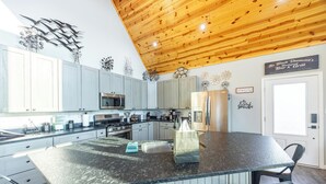 A modern kitchen with a large island, granite countertops, and stainless steel appliances. - Black Diamond-New Build, Ski, Hot Tub,  Views, BBQ, EV & AC (Davis)