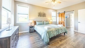 A bedroom with a bed, dresser, nightstands, and a ceiling fan. - Black Diamond-New Build, Ski, Hot Tub,  Views, BBQ, EV & AC (Davis)
