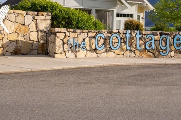 Un muro de piedra con el texto 'the cottage' en letras azules.