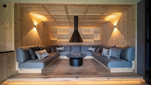 A cozy, wooden-paneled room with a central seating area featuring a sofa and a coffee table. - Hotel Seehof (Monguelfo)