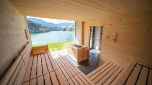 A wooden cabin with a view of a lake and mountains. - Hotel Seehof (Monguelfo)