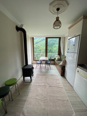 A kitchen with a dining area, a view of greenery outside, and a built-in refrigerator.
