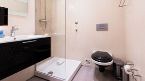 A modern bathroom with a glass-enclosed shower, a toilet, and a sink. - Bairro Alto Two Bedroom Apartment (Lisbon)