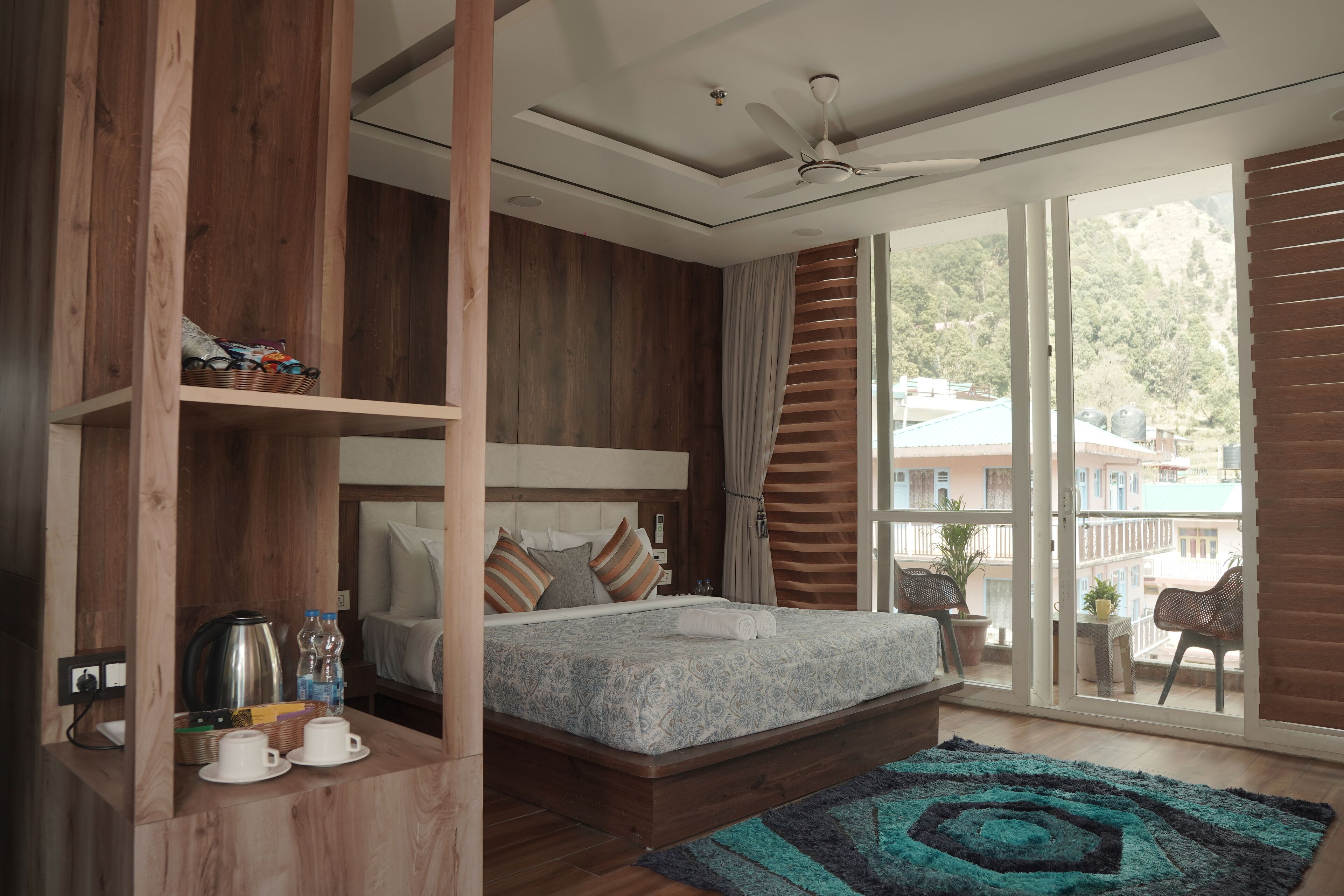 Un dormitorio moderno con una cama grande, estanterías de madera, una mesa de centro y vistas al exterior.