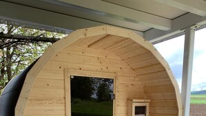 A wooden arched structure with a door, a small window, and a built-in bench. - Exceptional vacation apartment in modern style (Weiding)