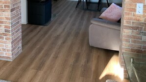 A cozy dining area with a brick wall, a black grill, and a wooden floor. - Exceptional vacation apartment in modern style (Weiding)
