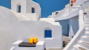 A white building with a blue dome and a staircase.
