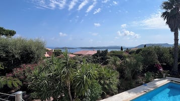 Piscina com vista desobstruída da paisagem ao redor, incluindo árvores e edifícios distantes.