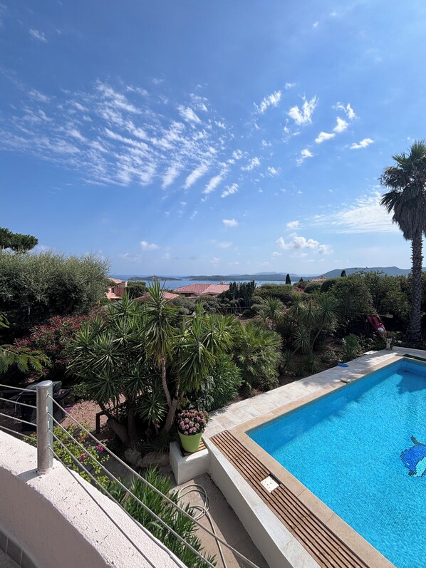 A swimming pool with a clear view of the surrounding landscape, including trees and distant buildings. - LA RUSCANA - Villa with Pool, Sea View, 600M from the Beach (Zonza)