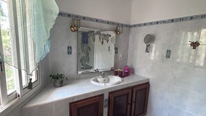 A bathroom with a sink, mirror, and cabinets.
