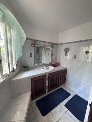 A bathroom with a sink, mirror, and cabinets.