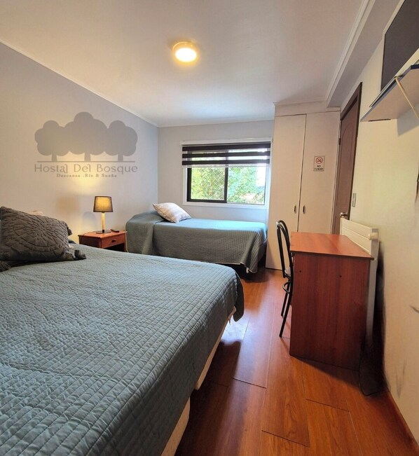 A hotel room with two beds, a nightstand, a lamp, a window with blinds, a wardrobe, and a sign indicating no smoking. - HOSTAL DEL BOSQUE TEMUCO (Temuco)