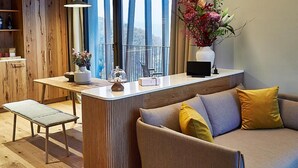 A modern living room with a sofa, bench, and a small table with decorative items. - Wald.Weit Rheingau Hotel und Retreat (Kiedrich)