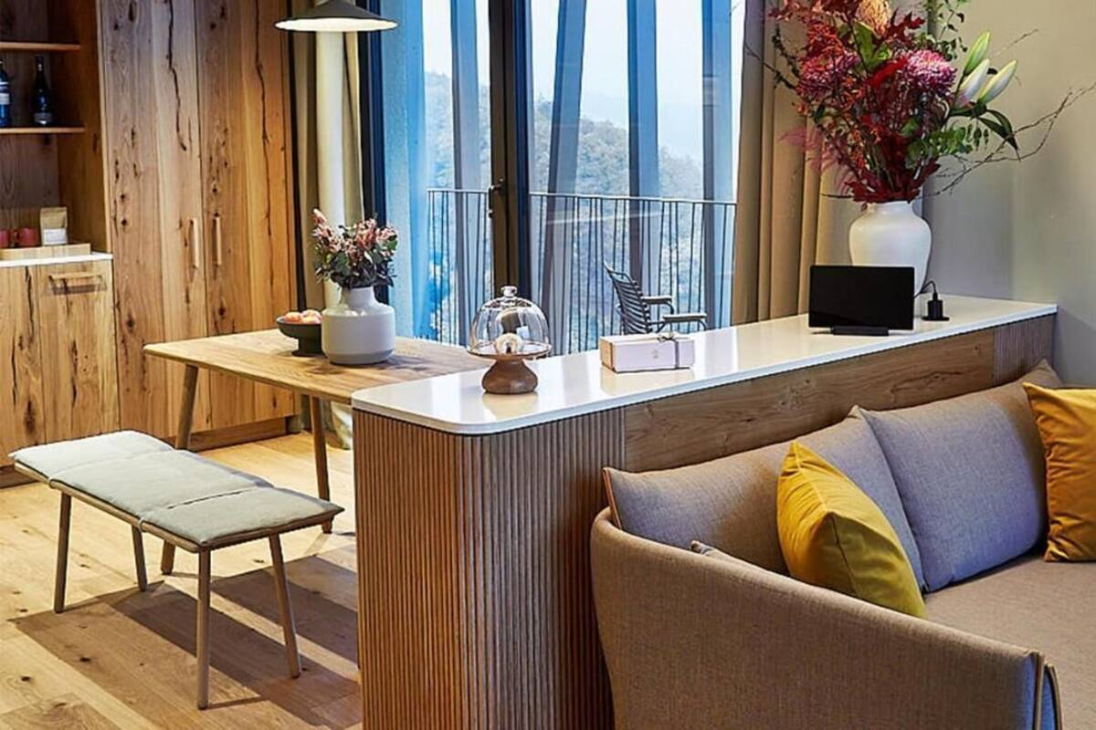 Ein modernes Wohnzimmer mit einer Couch, einer Bank und einem kleinen Tisch mit Dekoration.