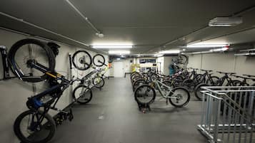 A bike storage area with multiple bicycles parked against the walls and on racks.
