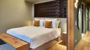 A modern bedroom with a large bed, wooden headboard, and a small bedside table. - Wald.Weit Rheingau Hotel und Retreat (Kiedrich)