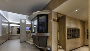 Un ascensor modern amb pantalla digital, paperer i teclat de seguretat.