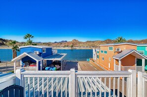 A coastal hotel with colorful buildings, a pool, and a view of the sea and mountains. - Sandy Cheeks, Deluxe Rive Views, Roadrunner Resort (Parker)