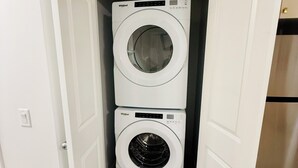 Ein Waschraum mit zwei übereinander gestapelten Whirlpool Waschmaschinen mit Frontlader.